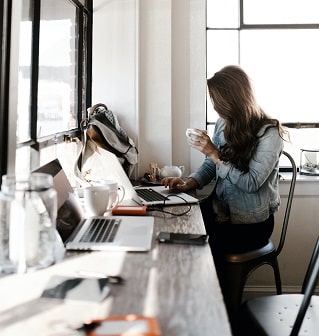 a woman sitting on her desk working on her computer