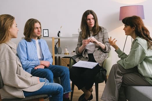 3 people having a group therapy with a therapist