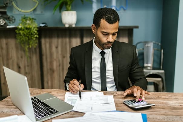 Accountant sitted at his desk working with a calculator