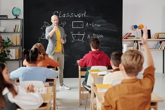 teacher in front of a classroom with children