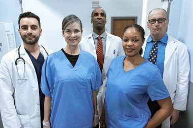 Doctors standing beside nursing assistants