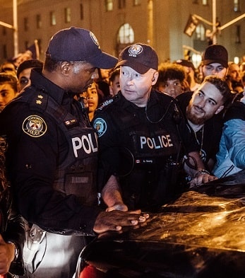 Police Officers surrounded by a people