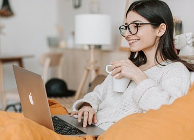 woman having coffee while working on laptop