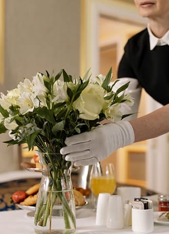 a woman is putting a flower pot on a table