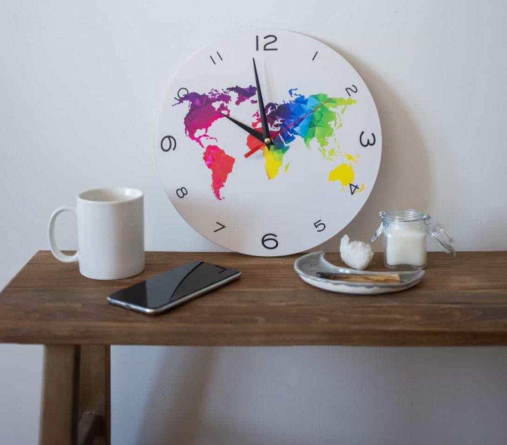 Clock with world map near smartphone