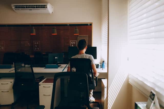 a guy on his computer facing his screen in an office