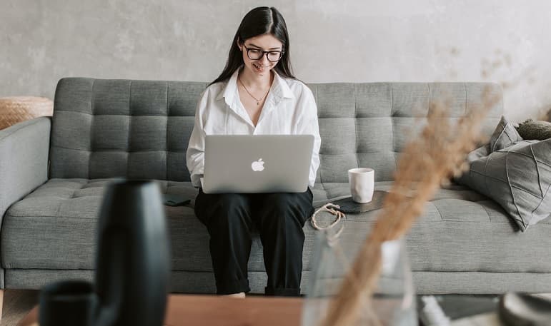 Woman working from home sitting on a sofa