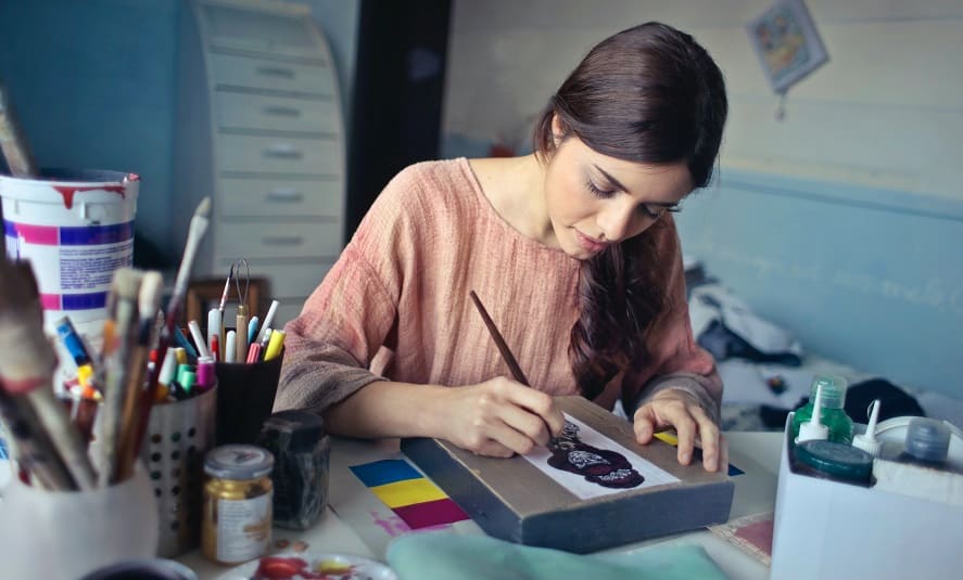 A woman in her artist's studio is painting